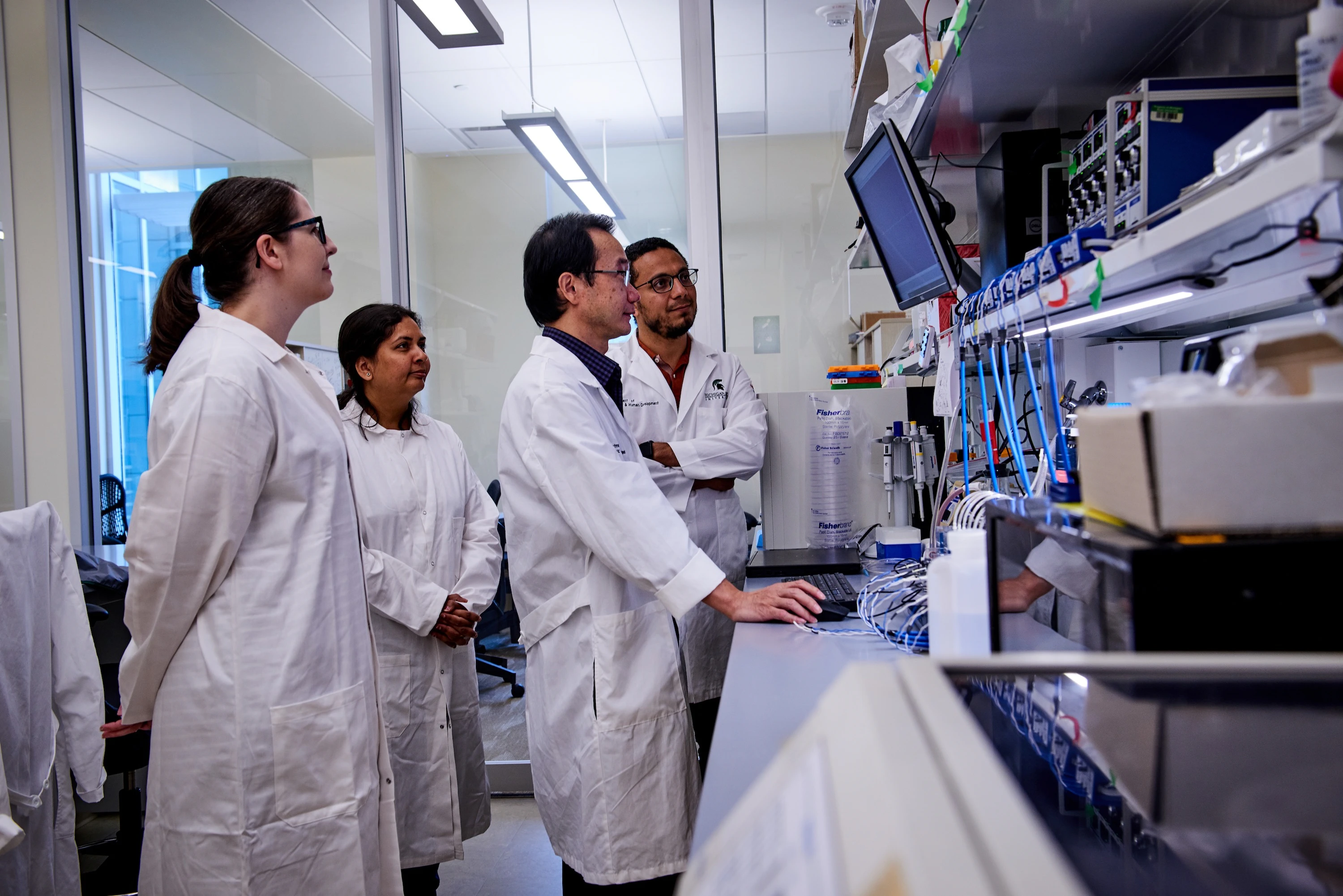 Xiaopeng Li, PhD, associate professor in MSU College of Human Medicine's Department of Pediatrics and Human Development, collaborates with his team in their Grand Rapids Research Center lab.